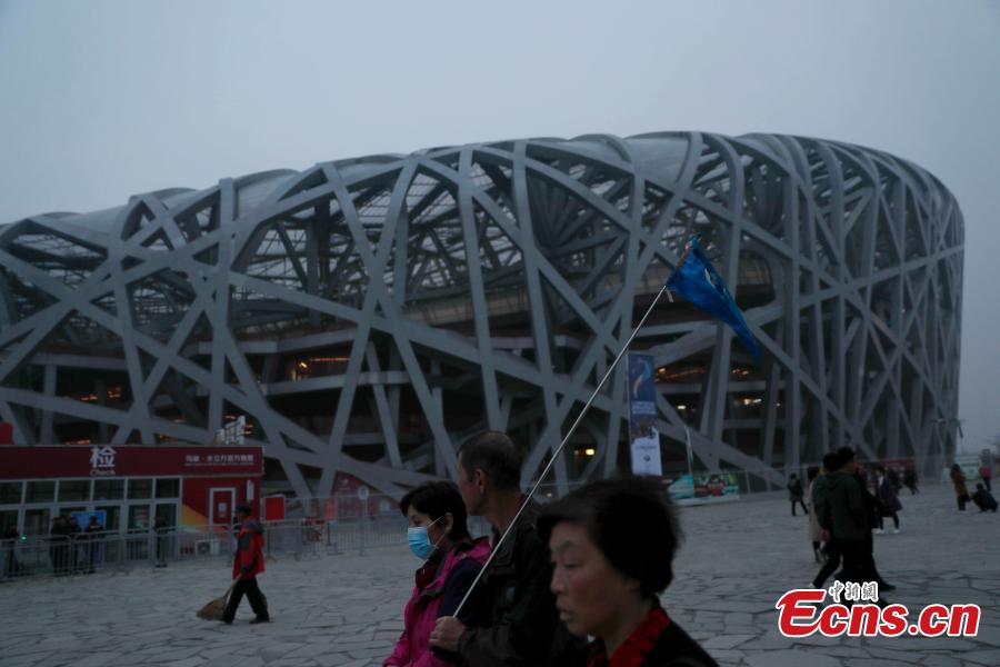 Tourists visit the area around National Stadium, also known as the Bird\'s Nest, on a smoggy day in Beijing, Oct. 14, 2018. Serious air pollution was reported in Beijing on Sunday. (Photo: China News Service/Liu Guanguan)