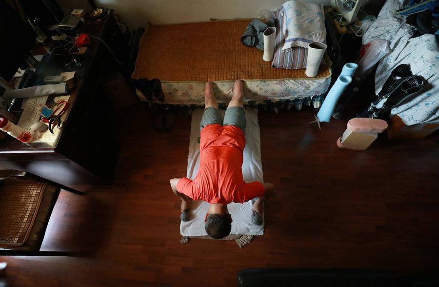 Xia practices push-ups at home. (Photo/China Daily)

\