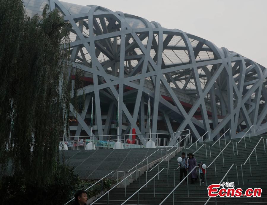 Tourists visit the area around National Stadium, also known as the Bird\'s Nest, on a smoggy day in Beijing, Oct. 14, 2018. Serious air pollution was reported in Beijing on Sunday. (Photo: China News Service/Liu Guanguan)