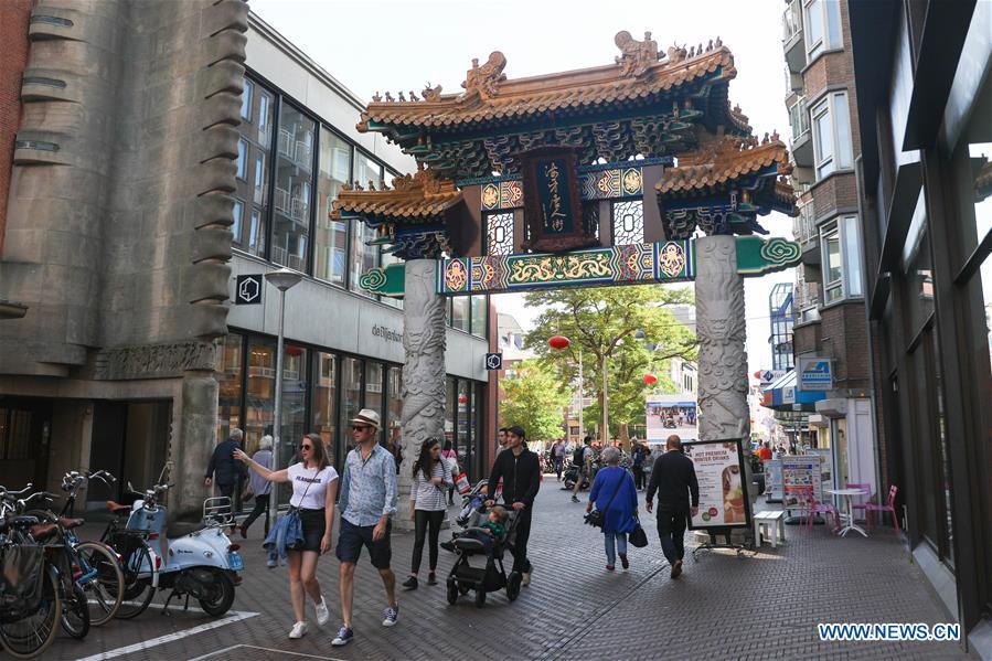 People walk through the traditional Chinese archway at the Chinatown in The Hague, the Netherlands, on Oct. 13, 2018. The Hague\'s Chinatown is located in the downtown area of the city. With red lanterns, Chinese restaurants, Chinese medicine service shops and other shops featuring Chinese culture, the street attracts many citizens and worldwide tourists. (Xinhua/Zheng Huansong)