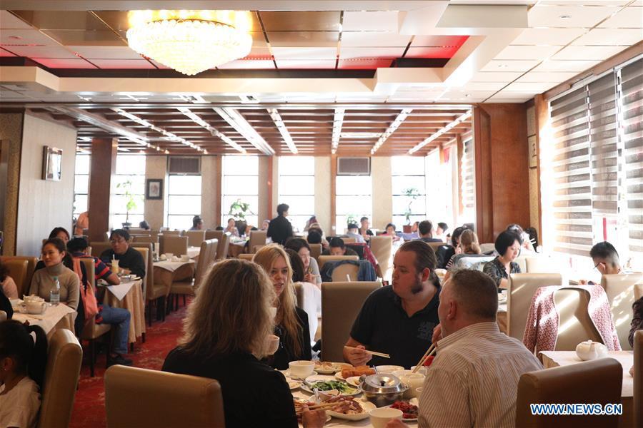 People enjoy Chinese food in a restaurant at the Chinatown in The Hague, the Netherlands, on Oct. 13, 2018. The Hague\'s Chinatown is located in the downtown area of the city. With red lanterns, Chinese restaurants, Chinese medicine service shops and other shops featuring Chinese culture, the street attracts many citizens and worldwide tourists. (Xinhua/Zheng Huanso
