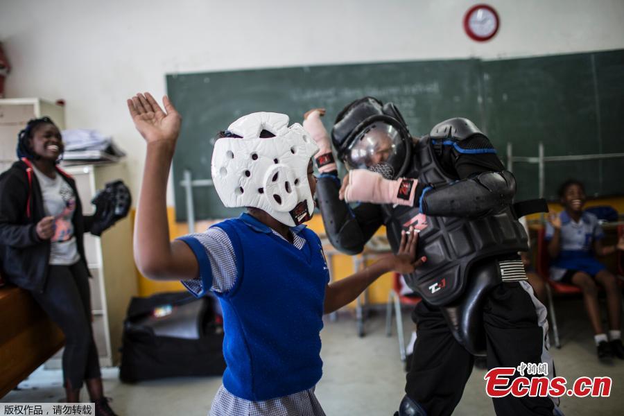 Girls practice self-defense methods on one of the instructors dressed in protective gear during a session with NGO Action Breaks Silence (ABS) called \'Empowerment through self-defense for women and girls\' which aims to create a world free form fear of gender based violence, on October 10, 2018, at Mbuyisa Makhubu Primary School in the area of Orlando West, in the South African township of Soweto. (Photo/Agencies)