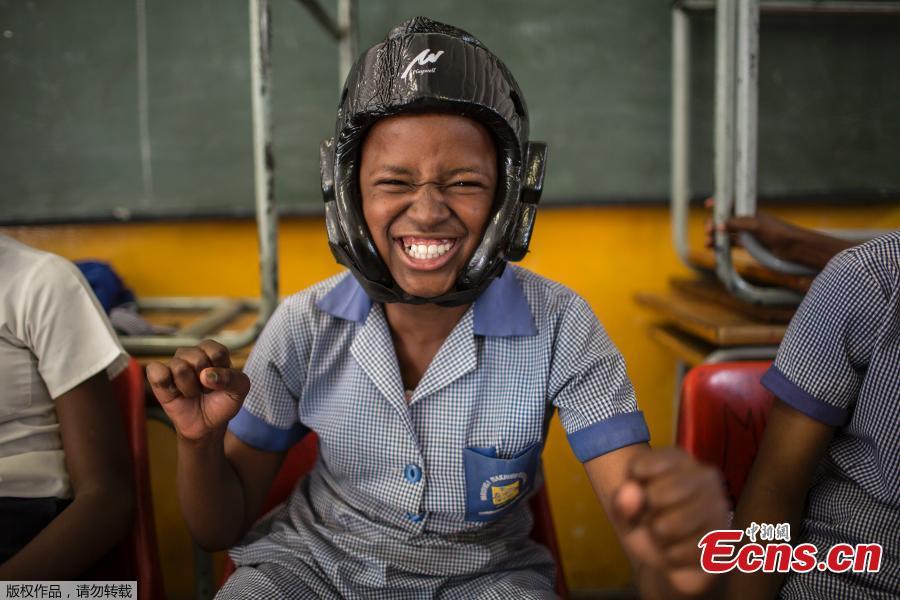 Phumzile Mapisa, 12, poses while wearing a helmet during a session with NGO Action Breaks Silence (ABS) called \'Empowerment through self-defense for women and girls\' which aims to create a world free form fear of gender based violence, on October 10, 2018, at Mbuyisa Makhubu Primary School in the area of Orlando West, in the South African township of Soweto. (Photo/Agencies)