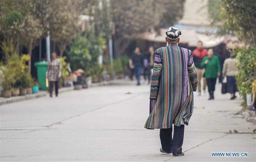 An elderly man dressed in traditional costume walks on a street in Kashgar City, northwest China\'s Xinjiang Uygur Autonomous Region, Oct. 16, 2018. The ancient oasis city of Kashgar, in the westernmost part of China near the border with Kyrgyzstan, Tajikistan, Afghanistan, and Pakistan, was an important staging post on the original Silk Road and has been revitalized as a bustling hub of business and different cultures. (Xinhua/Hu Huhu)