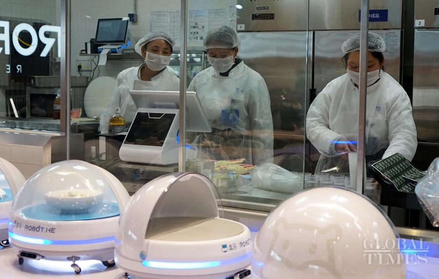 Robots wait for the finished dishes before delivering to hungry customers.  (Photos: Yang Hui/GT)