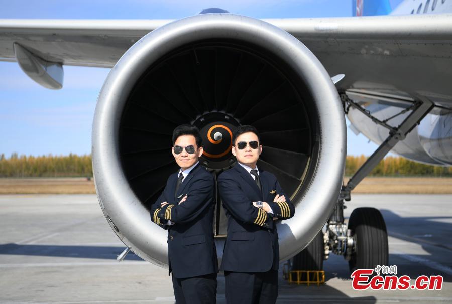 Twin brothers Liu Ke (L) and Liu Xin pose for a photo near a China Southern Airlines aircraft on Oct. 16, 2018. The twin brothers, born in 1987, were from a young age both interested in becoming pilots. After graduating high school, they both went on to study at the Civil Aviation Flight University of China. Later, both became pilots for China Southern Airlines. (Photo: China News Service/Zhang Yao)