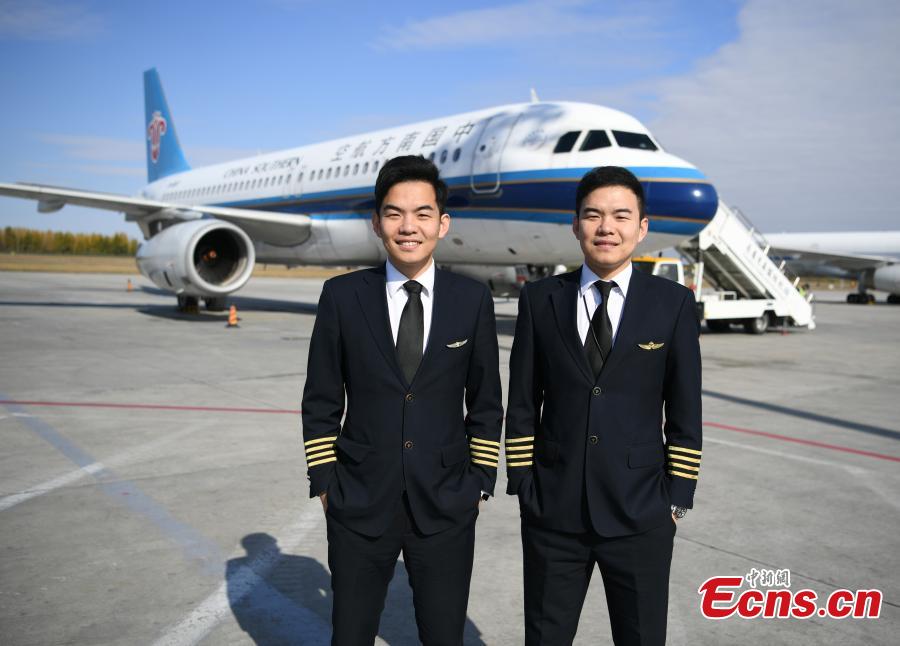 Twin brothers Liu Ke (L) and Liu Xin pose for a photo near a China Southern Airlines aircraft on Oct. 16, 2018. The twin brothers, born in 1987, were from a young age both interested in becoming pilots. After graduating high school, they both went on to study at the Civil Aviation Flight University of China. Later, both became pilots for China Southern Airlines. (Photo: China News Service/Zhang Yao)