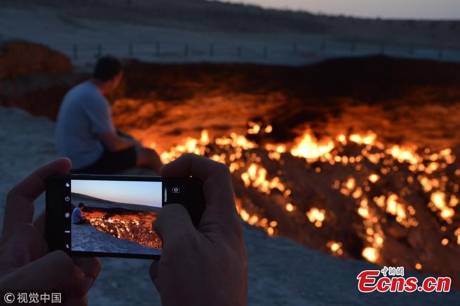 The \'Door to Hell,\' also known as the Crater of Fire, is a natural gas field in Derweze, Turkmenistan, that collapsed into an underground cavern in 1971, becoming a natural gas crater. Geologists set it on fire to prevent the spread of methane gas, and it has been burning continuously since then. The crater is a popular tourist attraction. (Photo/VCG)