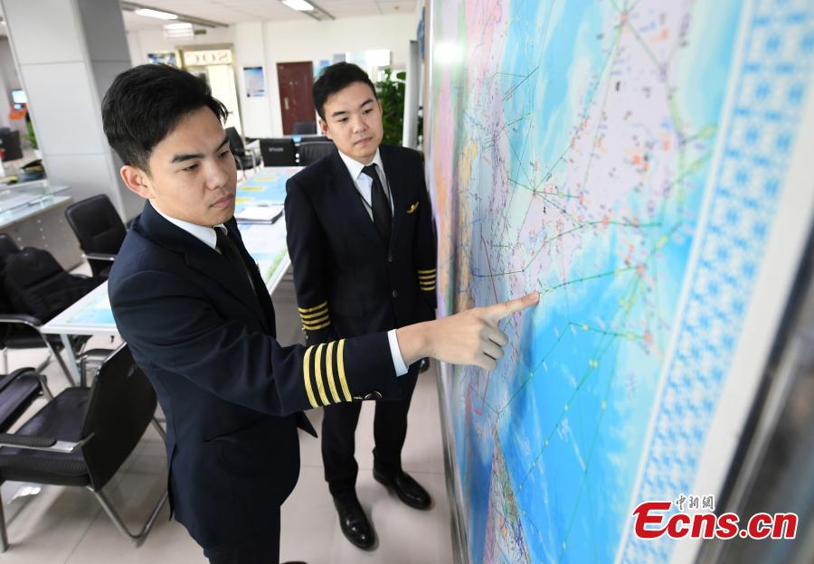Twin brothers Liu Ke (L) and Liu Xin study a flight map on Oct. 16, 2018. The twin brothers, born in 1987, were from a young age both interested in becoming pilots. After graduating high school, they both went on to study at the Civil Aviation Flight University of China. Later, both became pilots for China Southern Airlines. (Photo: China News Service/Zhang Yao)