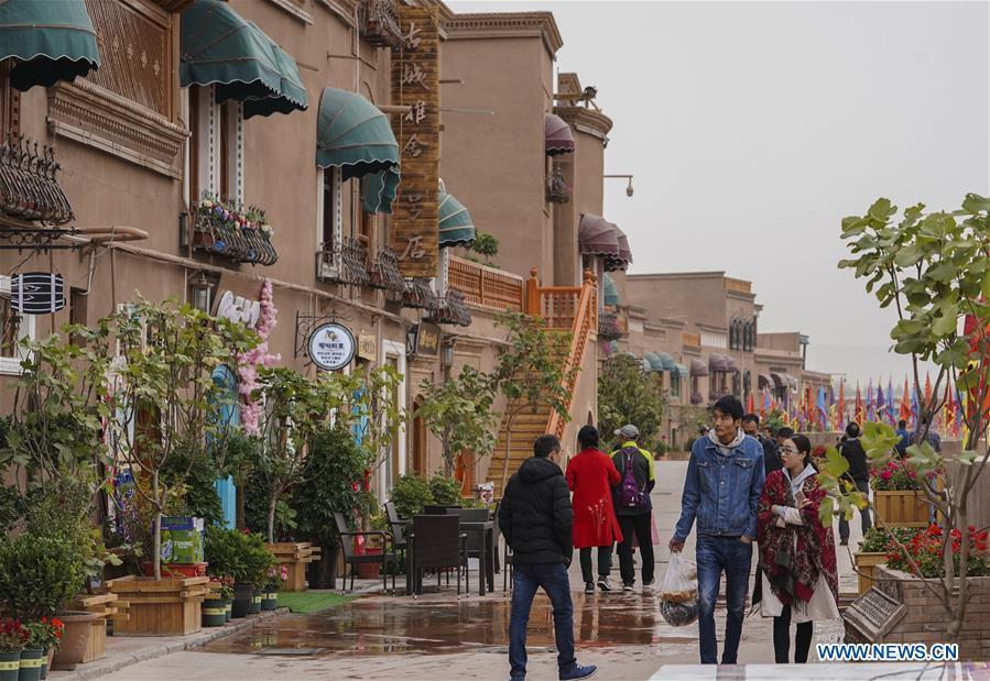 People walk on a shopping street in Kashgar City, northwest China\'s Xinjiang Uygur Autonomous Region, Oct. 16, 2018. The ancient oasis city of Kashgar, in the westernmost part of China near the border with Kyrgyzstan, Tajikistan, Afghanistan, and Pakistan, was an important staging post on the original Silk Road and has been revitalized as a bustling hub of business and different cultures. (Xinhua/Hu Huhu)