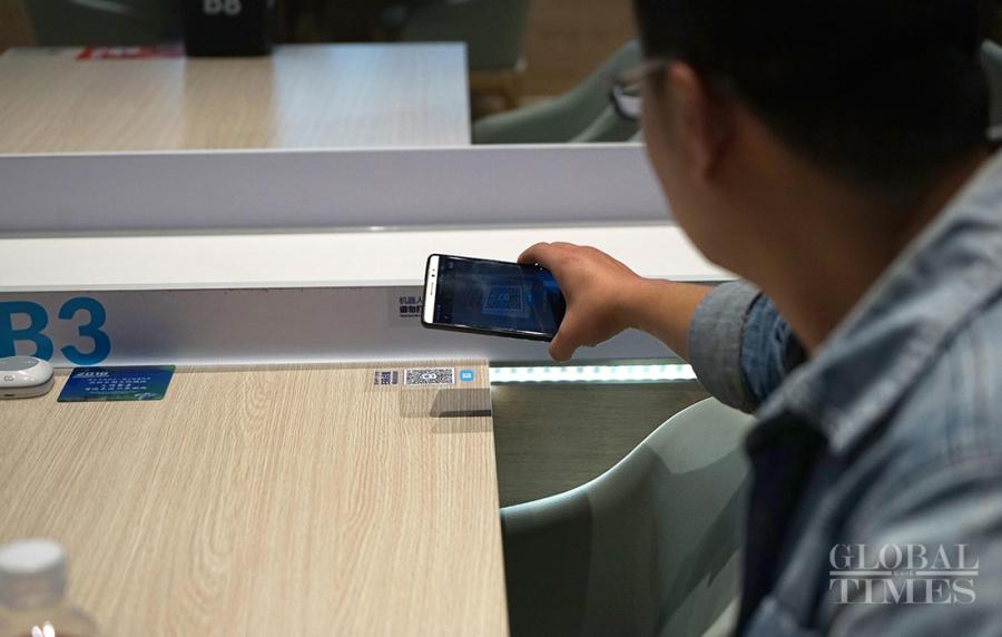 A customer scans a QR code so as to order his food. (Photos: Yang Hui/GT)

Diners at the China International Import Expo get to participate in a new dining experience. It’s as easy as sitting down and ordering through your phone. A few minutes later, a robot brings your food to your table and says, “Enjoy your meal.” The restaurant robot 2.0 introduces a new retailing technology combined with the dining scene.