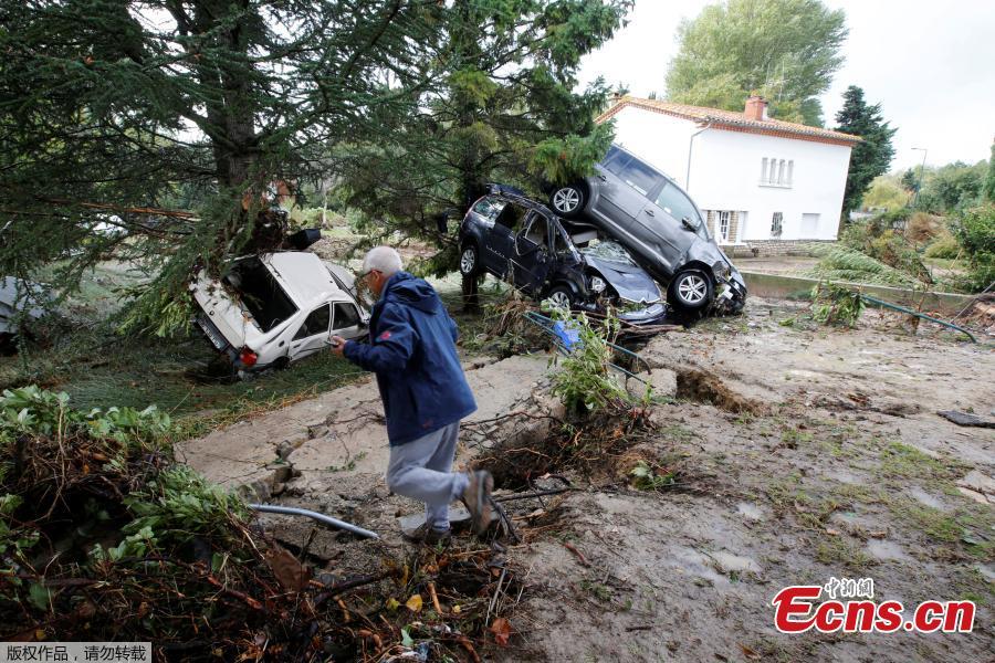 A man walks near damaged cars as clean-up operations continue the day after some of the worst flash floods in a century turned rivers into raging torrents that engulfed homes and swept away cars hit the southwestern Aude district of France, in Conques, France, Oct. 16, 2018. At least 12 people died. (Photo/Agencies)