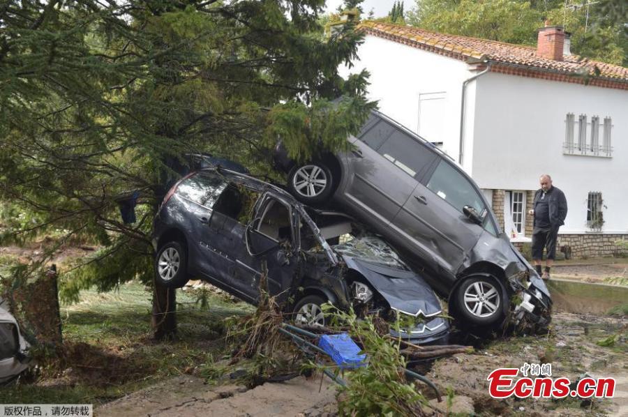 A man walks near damaged cars as clean-up operations continue the day after some of the worst flash floods in a century turned rivers into raging torrents that engulfed homes and swept away cars hit the southwestern Aude district of France, in Conques, France, Oct. 16, 2018. At least 12 people died. (Photo/Agencies)