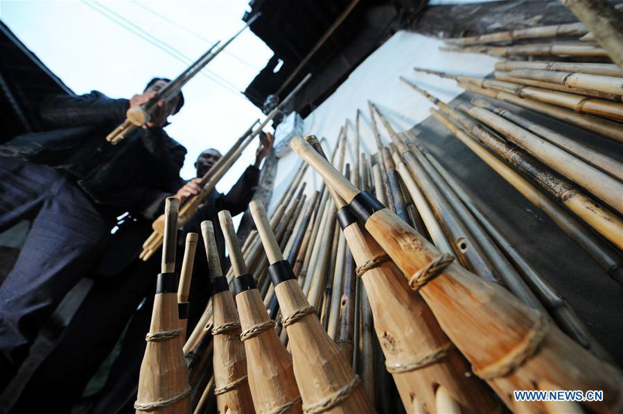 Craftsmen test the tone of finished Lushengs at Jinying Village in Congjiang County of Miao and Dong Autonomous Prefecture of Qiandongnan, southwest China\'s Guizhou Province, on Oct. 16, 2018. Lusheng is an ethnic musical instrument with multiple bamboo pipes set into a wooden blowing tube. It is popular among the people of some ethnic groups living in southwestern China. Jinying Village, known for making Lusheng, still keeps the traditional Lusheng making techniques which include over 30 steps such as choosing material, installing reed and whittling sound hole. People often play the Lusheng while gathering to celebrate some major festivals. (Xinhua/Yang Wenbin)