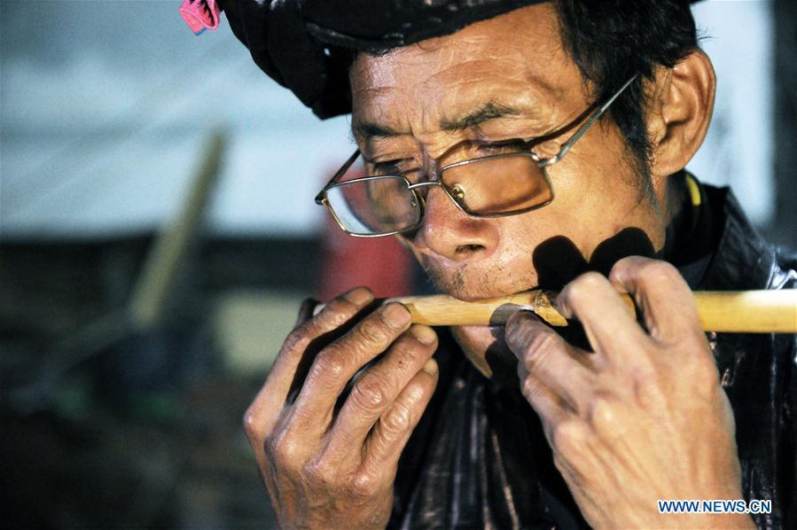 Craftsman Liang Zeguang tests the tone of a reed fitted in a bamboo pipe at Jinying Village in Congjiang County of Miao and Dong Autonomous Prefecture of Qiandongnan, southwest China\'s Guizhou Province, on Oct. 16, 2018. Lusheng is an ethnic musical instrument with multiple bamboo pipes set into a wooden blowing tube. It is popular among the people of some ethnic groups living in southwestern China. Jinying Village, known for making Lusheng, still keeps the traditional Lusheng making techniques which include over 30 steps such as choosing material, installing reed and whittling sound hole. People often play the Lusheng while gathering to celebrate some major festivals. (Xinhua/Yang Wenbin)