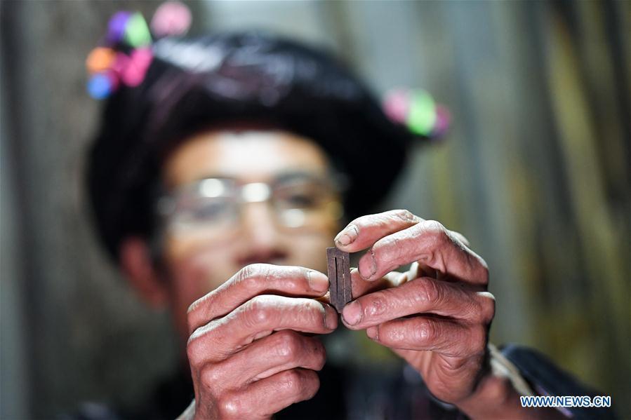 Craftsman Liang Zeguang checks a reed for Lusheng at Jinying Village in Congjiang County of Miao and Dong Autonomous Prefecture of Qiandongnan, southwest China\'s Guizhou Province, on Oct. 16, 2018. Lusheng is an ethnic musical instrument with multiple bamboo pipes set into a wooden blowing tube. It is popular among the people of some ethnic groups living in southwestern China. Jinying Village, known for making Lusheng, still keeps the traditional Lusheng making techniques which include over 30 steps such as choosing material, installing reed and whittling sound hole. People often play the Lusheng while gathering to celebrate some major festivals. (Xinhua/Chen Yehua)
