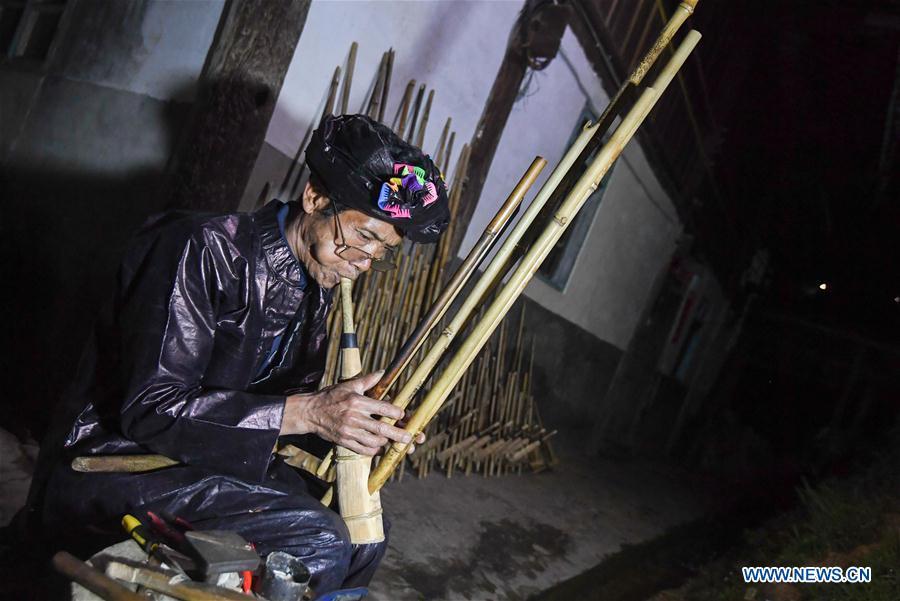 Craftsman Liang Zeguang tests the tone of a finished Lusheng at Jinying Village in Congjiang County of Miao and Dong Autonomous Prefecture of Qiandongnan, southwest China\'s Guizhou Province, on Oct. 16, 2018. Lusheng is an ethnic musical instrument with multiple bamboo pipes set into a wooden blowing tube. It is popular among the people of some ethnic groups living in southwestern China. Jinying Village, known for making Lusheng, still keeps the traditional Lusheng making techniques which include over 30 steps such as choosing material, installing reed and whittling sound hole. People often play the Lusheng while gathering to celebrate some major festivals. (Xinhua/Chen Yehua)