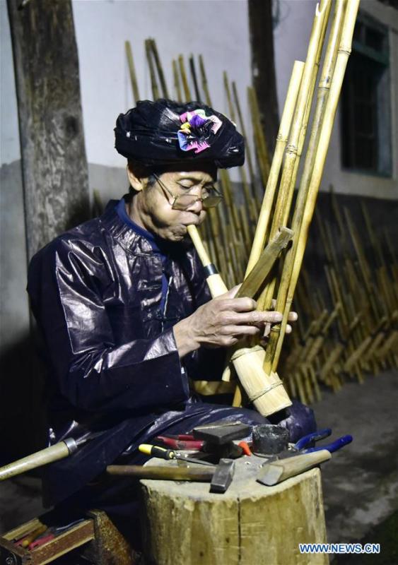Craftsman Liang Zeguang tests the tone of a finished Lusheng at Jinying Village in Congjiang County of Miao and Dong Autonomous Prefecture of Qiandongnan, southwest China\'s Guizhou Province, on Oct. 16, 2018. Lusheng is an ethnic musical instrument with multiple bamboo pipes set into a wooden blowing tube. It is popular among the people of some ethnic groups living in southwestern China. Jinying Village, known for making Lusheng, still keeps the traditional Lusheng making techniques which include over 30 steps such as choosing material, installing reed and whittling sound hole. People often play the Lusheng while gathering to celebrate some major festivals. (Xinhua/Wu Dejun)
