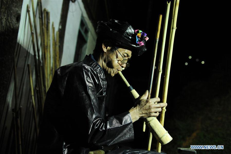 Craftsman Liang Zeguang tests the tone of a finished Lusheng at Jinying Village in Congjiang County of Miao and Dong Autonomous Prefecture of Qiandongnan, southwest China\'s Guizhou Province, on Oct. 16, 2018. Lusheng is an ethnic musical instrument with multiple bamboo pipes set into a wooden blowing tube. It is popular among the people of some ethnic groups living in southwestern China. Jinying Village, known for making Lusheng, still keeps the traditional Lusheng making techniques which include over 30 steps such as choosing material, installing reed and whittling sound hole. People often play the Lusheng while gathering to celebrate some major festivals. (Xinhua/Yang Wenbin)