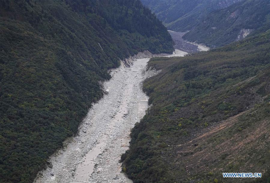 Aerial photo taken on Oct. 18, 2018 shows the dried-out lower reaches of the Yarlung Tsangpo River in Menling County, southwest China\'s Tibet Autonomous Region. More than 6,000 people have been evacuated after a barrier lake formed following a landslide in the Yarlung Tsangpo River in southwest China\'s Tibet Autonomous Region, local authorities said Thursday. According to the local disaster relief headquarters, the landslide struck during the early hours of Wednesday near a village in Menling County, blocking the river\'s waterway. The amounts of water in the lake has surpassed 300 million cubic meters. No casualties have been reported. Authorities in Tibet have launched an emergency response, monitoring the lake\'s water level, evacuating local residents and sending relief supplies to the disaster-hit areas. (Xinhua/Purbu Zhaxi)