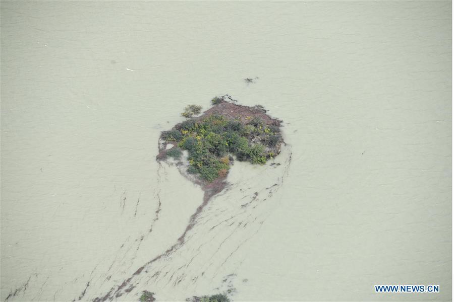 Aerial photo taken on Oct. 18, 2018 shows the barrier lake on the Yarlung Tsangpo River in Menling County, southwest China\'s Tibet Autonomous Region. More than 6,000 people have been evacuated after a barrier lake formed following a landslide in the Yarlung Tsangpo River in southwest China\'s Tibet Autonomous Region, local authorities said Thursday. According to the local disaster relief headquarters, the landslide struck during the early hours of Wednesday near a village in Menling County, blocking the river\'s waterway. The amounts of water in the lake has surpassed 300 million cubic meters. No casualties have been reported. Authorities in Tibet have launched an emergency response, monitoring the lake\'s water level, evacuating local residents and sending relief supplies to the disaster-hit areas. (Xinhua/Purbu Zhaxi)