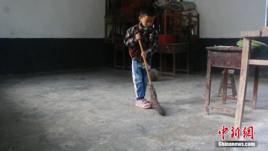 Wang Longze helps clean the classroom at an elementary school on a mountain in Xuanhan County, Southwest China’s Sichuan Province in mid-October. Four students left to study at a larger school this autumn semester, leaving only Wang from a poor family to study there. Wang’s father is disabled and suffers from disease, and his mother died not long after he was born. Lai has decided to stay in the school to teach Wang. (Photo: China News Service/Zhong Xin)