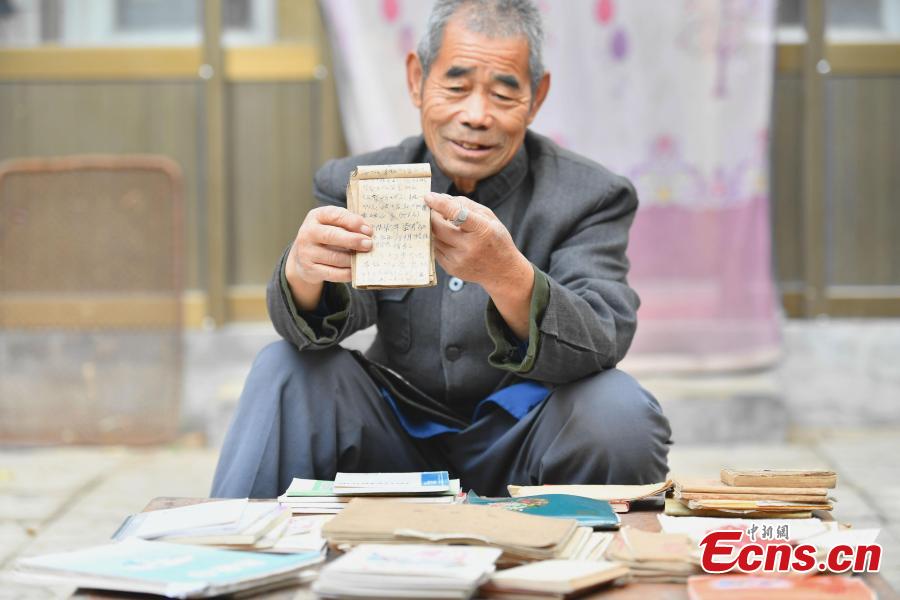 Farmer Jia Zengwen shows a diary he began to write 60 years ago at his home in Niujia Village, Gaocheng City, North China’s Hebei Province, Oct. 18, 2018. Jia has filled 108 diaries over the years, and they include records of his first time receiving the subsidy, a medical insurance claim, and the pension. The diaries also provide a record of the change that has taken place in his rural home over the past 40 years of reform and opening up. (Photo: China News Service/Zhai Yujia)