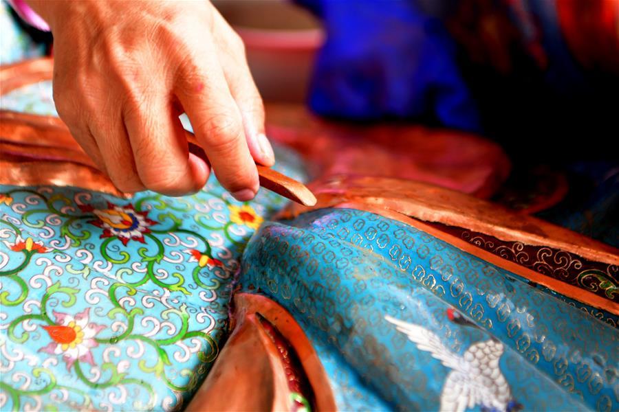 Lin Hui works on an enamelwork in Putian, southeast China\'s Fujian Province, Oct. 18, 2018. Lin Hui is an intangible cultural heritage inheritor of Lin\'s cloisonne, or copper padding thread weaving enamel, a kind of traditional Chinese handicrafts. (Xinhua/Wei Peiquan)