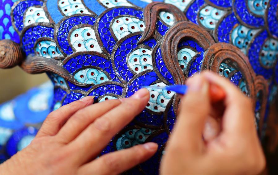Lin Hui works on an enamelwork in Putian, southeast China\'s Fujian Province, Oct. 18, 2018. Lin Hui is an intangible cultural heritage inheritor of Lin\'s cloisonne, or copper padding thread weaving enamel, a kind of traditional Chinese handicrafts. (Xinhua/Wei Peiquan)
