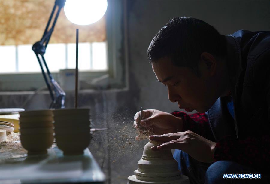 A craftsman named Jiang Peihua polishes the earthen body of an eggshell porcelain in Jingdezhen, east China\'s Jiangxi Province, on Oct. 19, 2018. Eggshell porcelain, one of the traditional porcelains produced in \