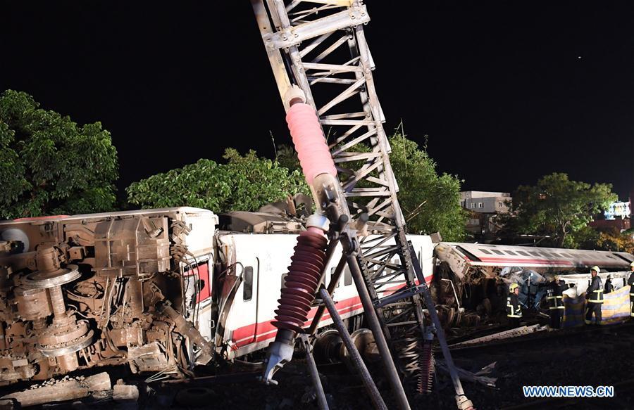 Photo taken on Oct. 21, 2018 shows the train derailment site in Yilan County, southeast China\'s Taiwan. At least 18 people died and another 120 injured, after a passenger train derailed in Taiwan on Sunday afternoon, according to the island\'s railway authority. The Puyuma Express No. 6432 bound for Taitung from Shulin Station with 366 passengers on board derailed at 4:50 p.m. local time at Su\'aoxin Station in Yilan County. A total of 17 people were declared dead before being sent to hospital. Five of the eight cars of the express train overturned. The cause of the derailment is still under investigation. (Xinhua/Jin Liangkuai)