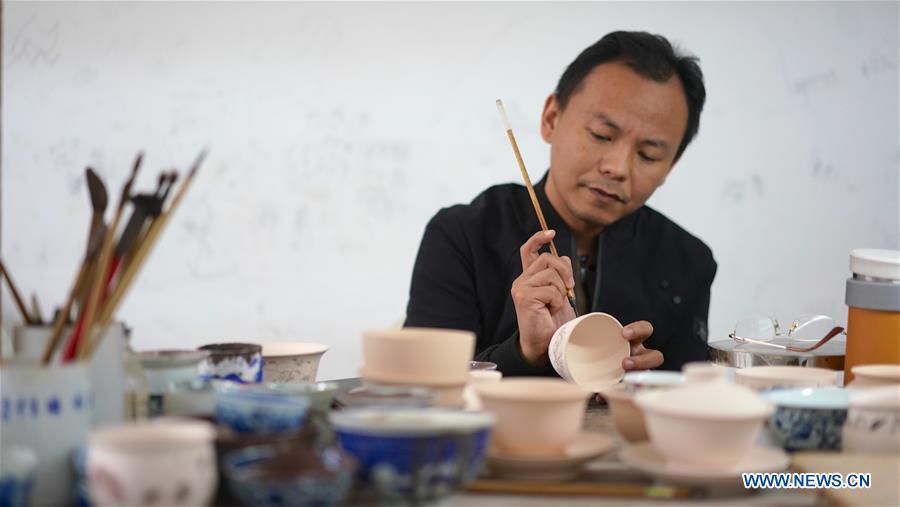 A craftsman named Liu Zhen paints on the body of an eggshell porcelain in Jingdezhen, east China\'s Jiangxi Province, on Oct. 19, 2018. Eggshell porcelain, one of the traditional porcelains produced in \