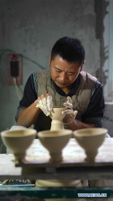 A craftsman named Zhang Rong makes the earthen body of an eggshell porcelain in Jingdezhen, east China\'s Jiangxi Province, on Oct. 19, 2018. Eggshell porcelain, one of the traditional porcelains produced in \