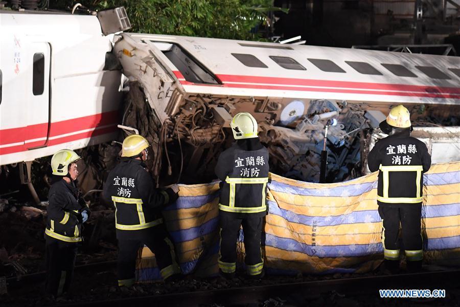 Photo taken on Oct. 21, 2018 shows the rescuing site of the train derailment accident in Yilan County, southeast China\'s Taiwan. At least 18 people died and another 120 injured, after a passenger train derailed in Taiwan on Sunday afternoon, according to the island\'s railway authority. The Puyuma Express No. 6432 bound for Taitung from Shulin Station with 366 passengers on board derailed at 4:50 p.m. local time at Su\'aoxin Station in Yilan County. A total of 17 people were declared dead before being sent to hospital. Five of the eight cars of the express train overturned. The cause of the derailment is still under investigation. (Xinhua/Jin Liangkuai)