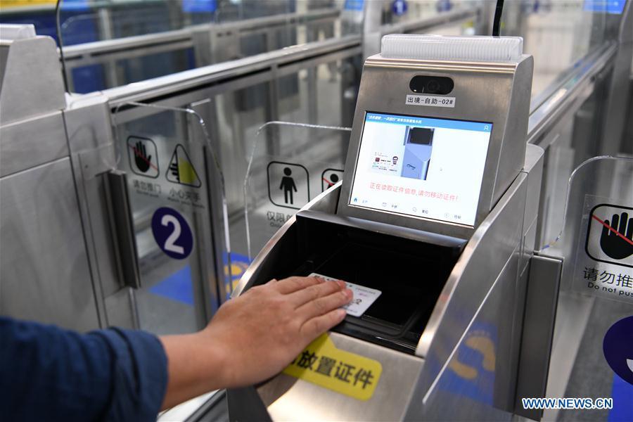 A staff worker demonstrates passing through an automatic channel in Zhuhai Port of Hong Kong-Zhuhai-Macao Bridge in Zhuhai, south China\'s Guangdong Province, Oct. 18, 2018. Customs clearance between Macao and Zhuhai will be carried out on a \