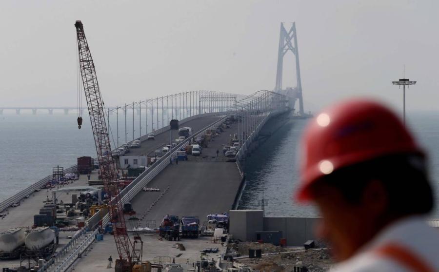 The bridge seen during construction in November 2017. (Photo by ROY LIU/CHINA DAILY)
6. When did construction start? What was the cost?

The plan to build a link road across the Pearl River Estuary was first initiated by Hong Kong industrialist Gordon Wu Ying-sheung in 1983. After several twists and turns, the Feasibility Study started in March 2004 under State Council\'s approval. The study report was approved in October 2009, followed by a commencement ceremony on Dec 15 in the same year, chaired by then-vice-premier Li Keqiang in Zhuhai.

So far, the total cost of HZMB is about 120 billion yuan ($17.4 billion), of which the 29.6-km Main Bridge invested by three governments is about 48.1 billion yuan. The rest are investments by individual governments on their ports and link roads to the Main Bridge.

The cost allocation among the three governments shown as above is settled by the assessment of economic benefits they can get after the bridge opens.