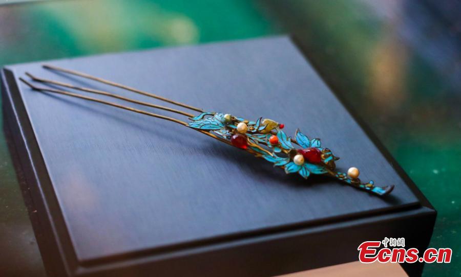 Artist Ma Jingji shows 30 pieces of Diancui works he has collected or created at an exhibition in Chongqing, Oct. 22, 2018. Diancui, or dotting with kingfishers, is a painstakingly time-consuming and precise practice of inlaying iridescent kingfisher feathers into accessories for the rich and noble. Craftsmen apply the shimmering feathers to jewelry, hairpins, bracelets, brooches, fans, and landscape panels. Instead of kingfisher feathers, goose feathers and ribbons are used nowadays to make art creations with diancui skills.(Photo: China News Service/Zhong Xin)