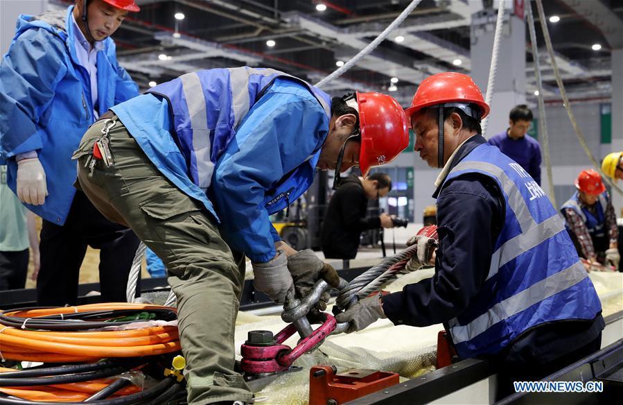 Workers make preparation for lifting operation of Taurus milling machine in Shanghai, east China, Oct. 22, 2018. Preliminary assembly of the milling machine, which will be the largest exhibit to be on show at China\'s upcoming import expo, was finished here on Monday. The exhibit is expected to cover 200 square meters of exhibiting space during the expo, which is scheduled to be held in Shanghai on Nov. 5-10. (Xinhua/Fang Zhe)