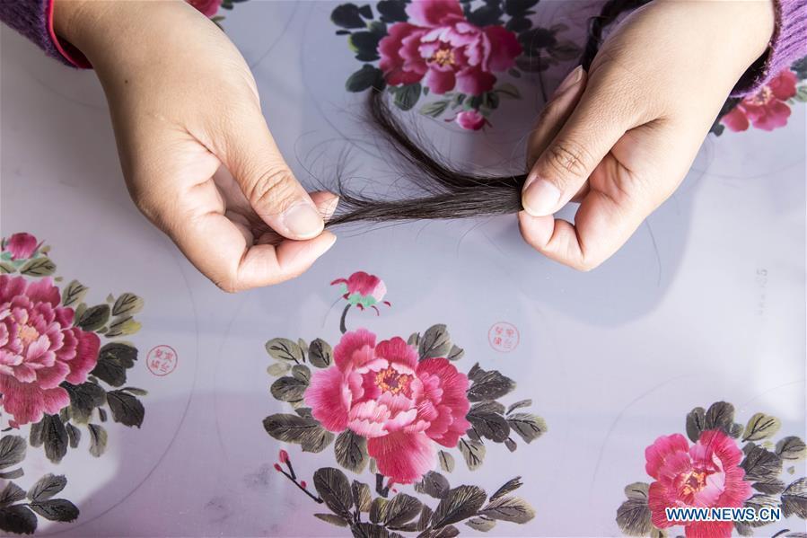 A local artist selects hairs for embroidery works in Dongtai, east China\'s Jiangsu Province, Oct. 22, 2018. (Xinhua/Xiang Zhonglin)