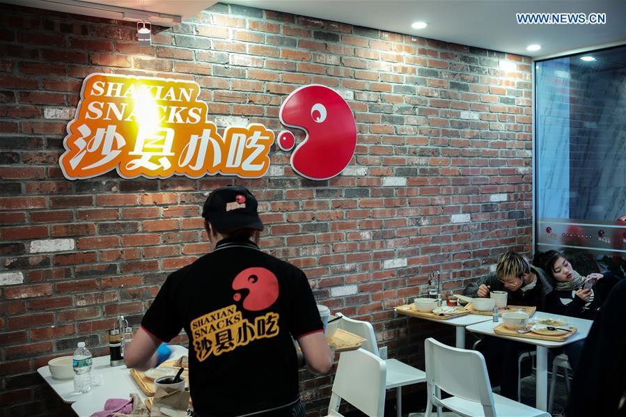 People enjoy their meal in Shaxian Snacks restaurant in Brooklyn, New York, the United States, on Oct. 21, 2018. China\'s restaurant chain serving Shaxian County cuisine has opened its first eatery in the United States. Located at 818, 60th St. Brooklyn, the restaurant, which opened Monday, presents overseas foodies with traditional Chinese snacks, including peanut butter noodles and pork wontons. (Xinhua/Li Muzi)