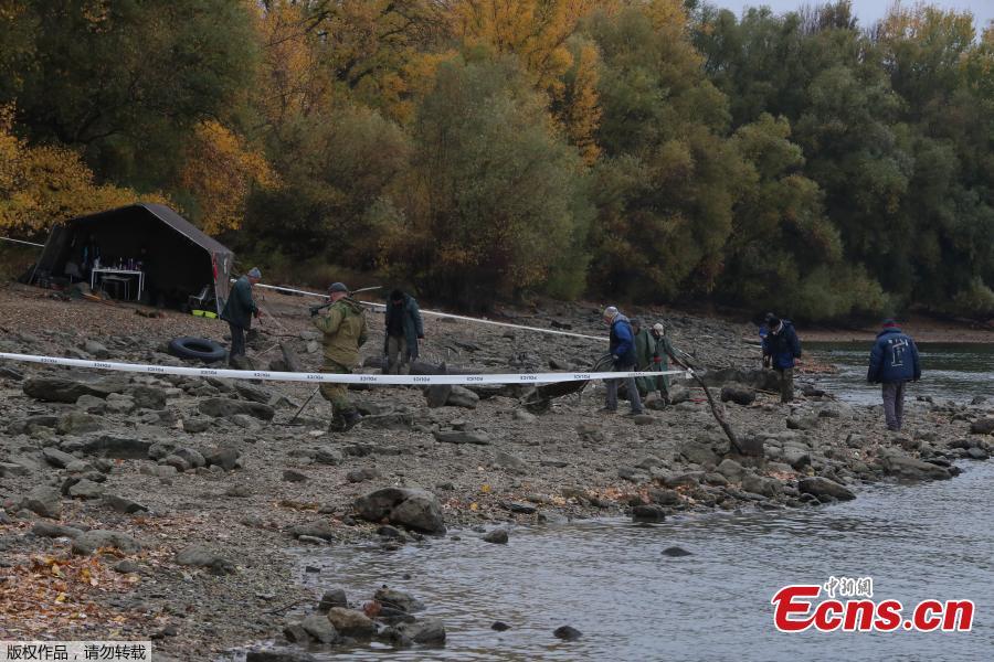 Hungarian archaeologists inspect the site where they found coins from the 16th-17th centuries and special weapons on the banks of the Danube river due to its low water level on October 25, 2018 near Erd, located 25 kilometers from Budapest. According to archaeologists working on site, the treasure comes from a cargo of a commercial ship that probably sank in the 18th century. (Photo/Agencies)