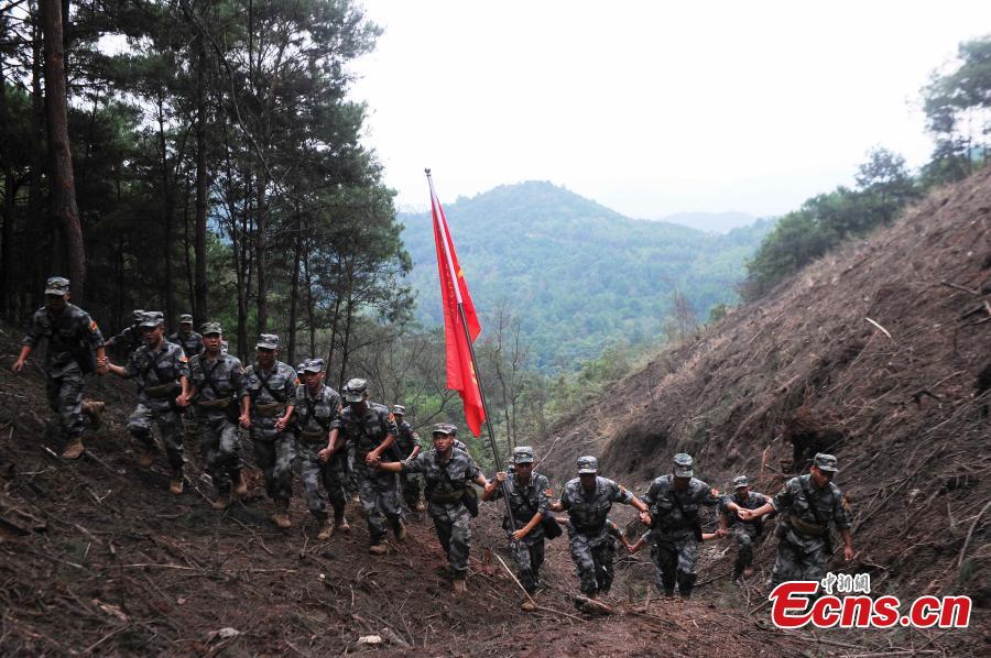 Hand-in-hand, soldiers walk across part of the minefield in the border city of Pingxiang before handing the landmine-free field over to the locals. The PLA soldiers detonated on Thursday, Oct. 25, 2018 the last mine in a minefield in Pingxiang. The operation marked the completion of a years-long landmine-sweeping mission in the Guangxi section of the Sino-Vietnam border, clearing the dangerous historical legacy that has hindered border development. (Photo: China News Service/Jiang Xuelin)