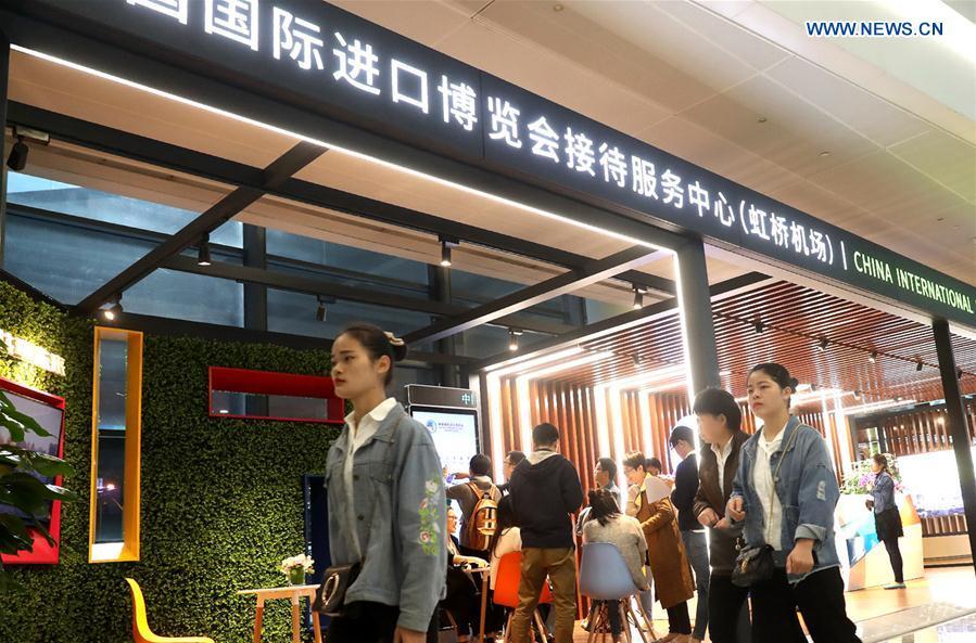 Passengers walk passing a service center for the first China International Import Expo (CIIE) at Pudong International Airport in Shanghai, east China, Oct. 24, 2018. The CIIE will be held in Shanghai on Nov. 5-10. (Xinhua/Chen Fei)