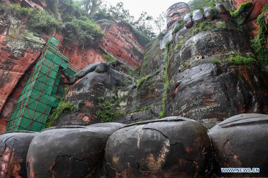 Workers install scaffolds for the examination work of the Leshan Giant Buddha in Leshan City, southwest China\'s Sichuan Province, Oct. 19, 2018. The examination of Leshan Giant Buddha started on Oct. 8 to collect data for better restoration. (Xinhua/Zhang Chaoqun)