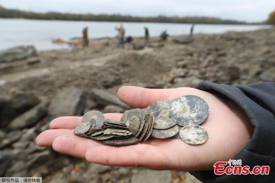 Hungarian archaeologists inspect the site where they found coins from the 16th-17th centuries and special weapons on the banks of the Danube river due to its low water level on October 25, 2018 near Erd, located 25 kilometers from Budapest. According to archaeologists working on site, the treasure comes from a cargo of a commercial ship that probably sank in the 18th century. (Photo/Agencies)