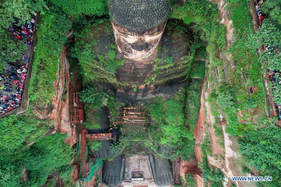 Tourists view the Leshan Giant Buddha in Leshan City, southwest China\'s Sichuan Province, Oct. 19, 2018. The examination of Leshan Giant Buddha started on Oct. 8 to collect data for better restoration. (Xinhua/Chen Minxiang)