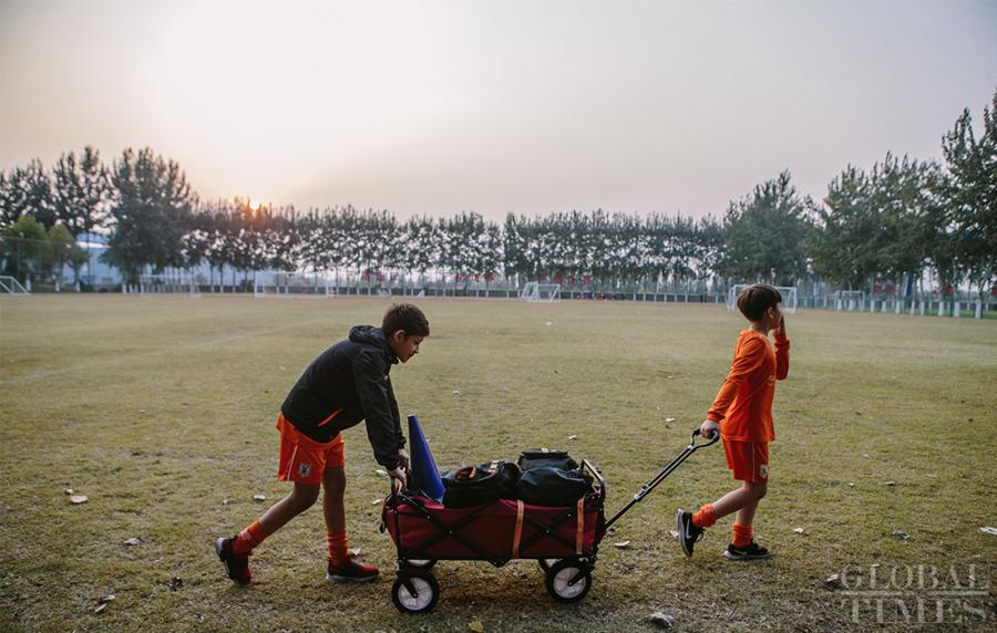 Two young players return the training equipment to the warehouse after training at the Shandong Luneng Taishan Football School in Weifang, East China\'s Shandong Province, on October 24, 2018.  (Photo: Li Hao/GT)