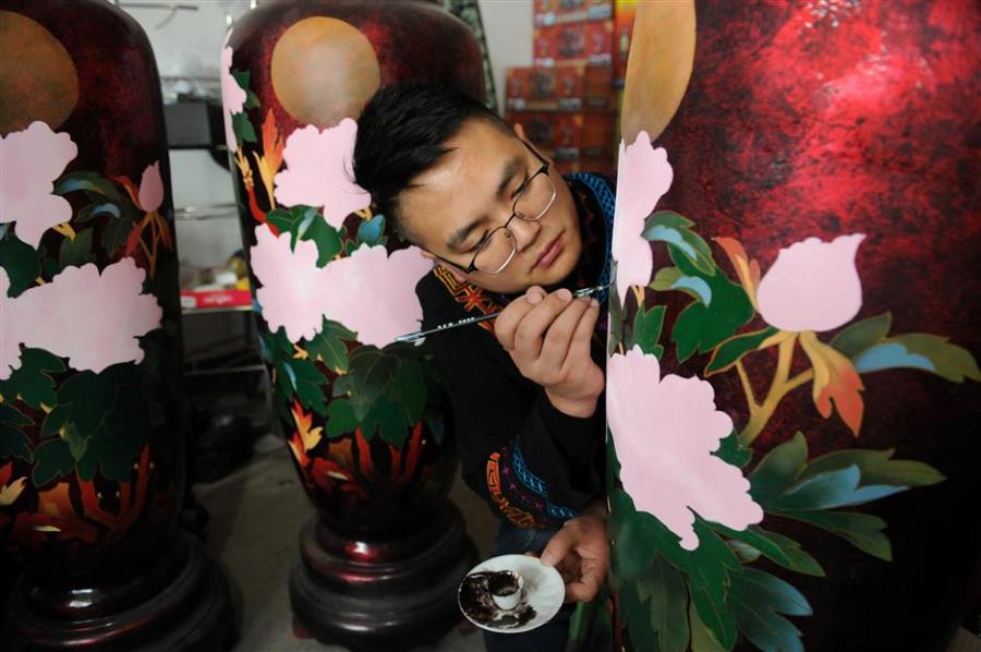 Gao Yan adds the finishing flourishes to a lacquer vase. Gao is a master of Dafang lacquerware, an irresistible part of China\'s cultural heritage. (Photo/Xinhua)

“We are working to increase investment and seeking cooperations to ensure the art form’s survival,” he adds.

Che Dan, director of the Dafang office of cultural industry, says, “Traditional skills and concepts need to seek new opportunities like combining lacquerware with modern furniture.

“There is also potential to expand consumption in through tourism.”