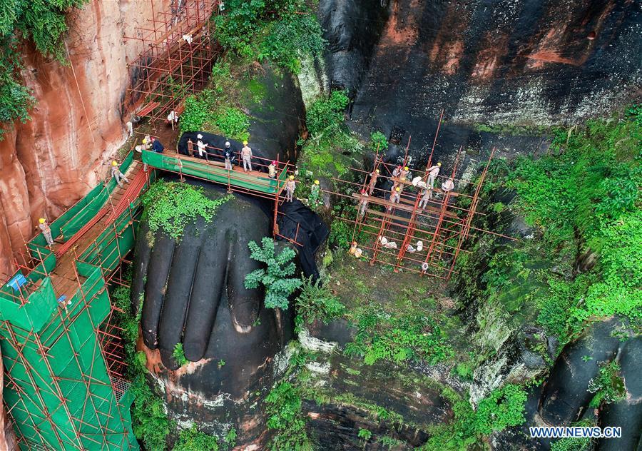 Workers install scaffolds for the examination work of the Leshan Giant Buddha in Leshan City, southwest China\'s Sichuan Province, Oct. 19, 2018. The examination of Leshan Giant Buddha started on Oct. 8 to collect data for better restoration. (Xinhua/Chen Minxiang)