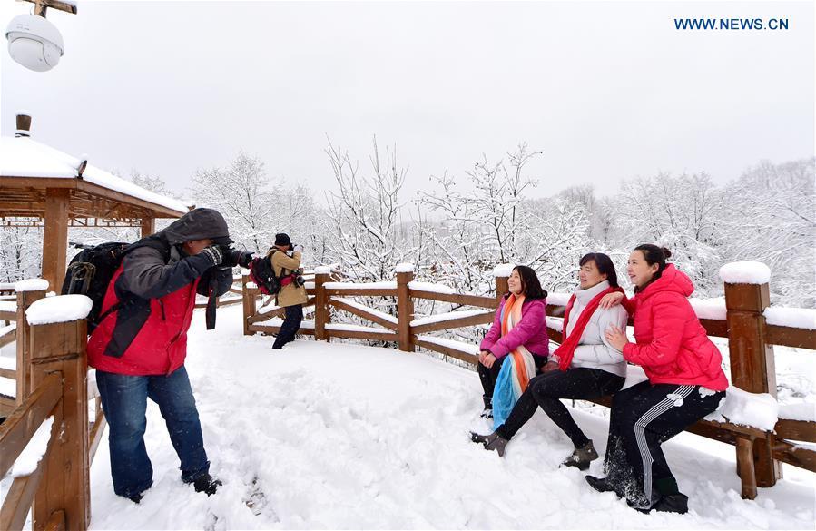 People enjoy the snow scenery at a scenic spot in Oroqen Autonomous Banner of Hulun Buir, north China\'s Inner Mongolia Autonomous Region, Oct. 26, 2018. A snowfall hit Oroqen Autonomous Banner of Hulun Buir on Friday.(Xinhua/Hou Yupeng)